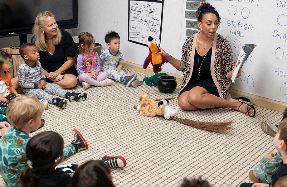 Teachers and children gathered on a classroom rug during a group activity
